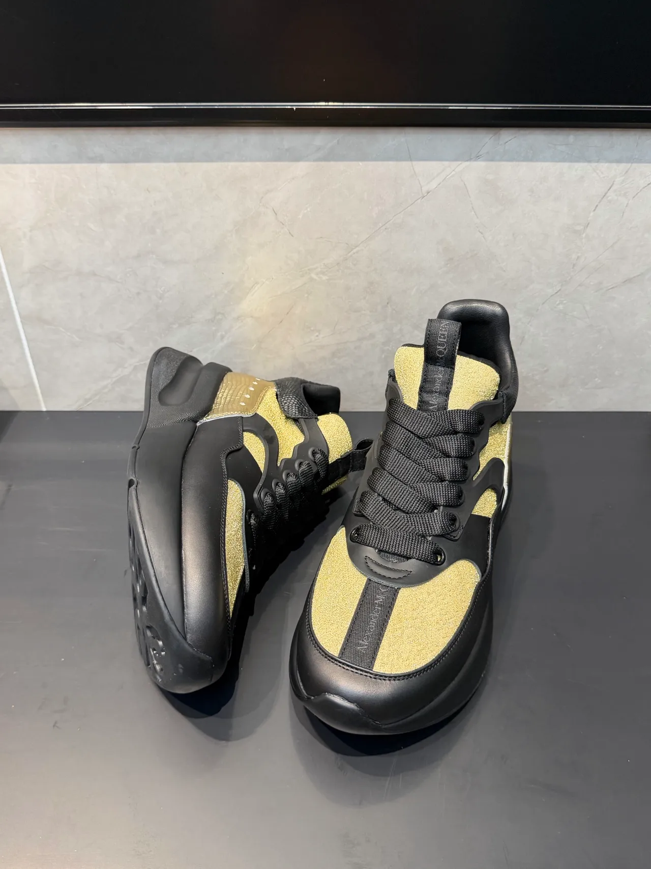 Alexander McQueen काला सोना ओवरसाइज सिल्हूट चमकदार पैनल मोटे स्नीकर्स 3