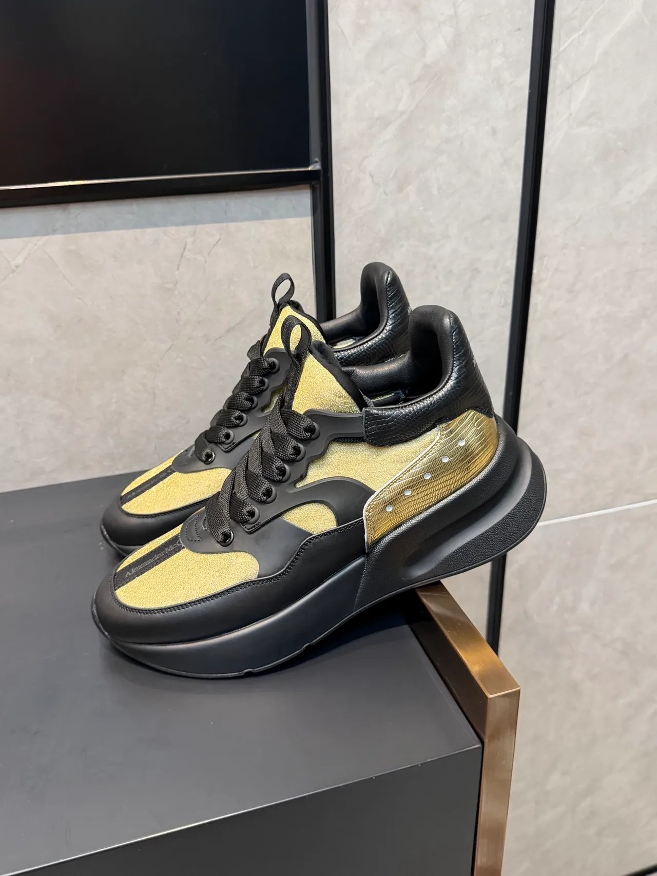 Alexander McQueen काला सोना ओवरसाइज सिल्हूट चमकदार पैनल मोटे स्नीकर्स 4