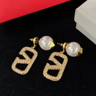 Brincos com pino de pérola de tom dourado com cristais e design geométrico