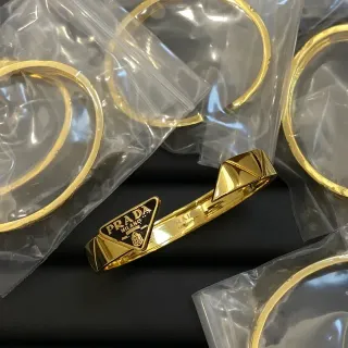 Prada सुनहरी काली धातु त्रिकोणीय लोगो प्लेक ब्रेसलेट