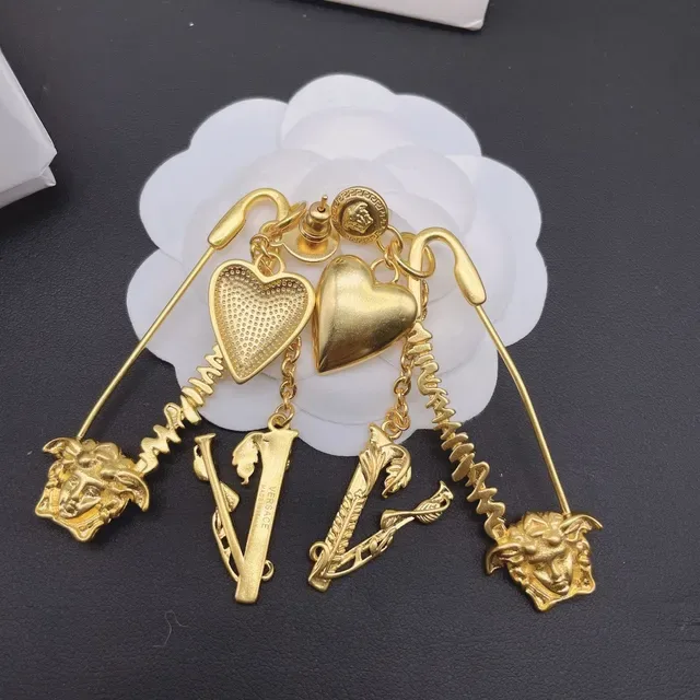 Versace Boucles d'oreilles dorées à la chaîne de cœur et pendentif Médusa 2