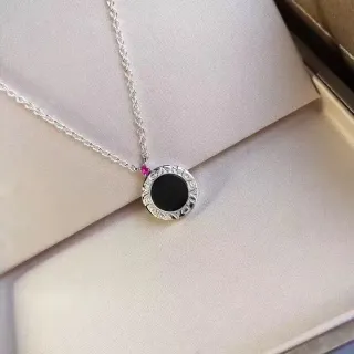 Collar con dije circular negro y rosa en el centro