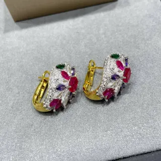Aros de tono dorado con múltiples gemas en cluster con bisagra