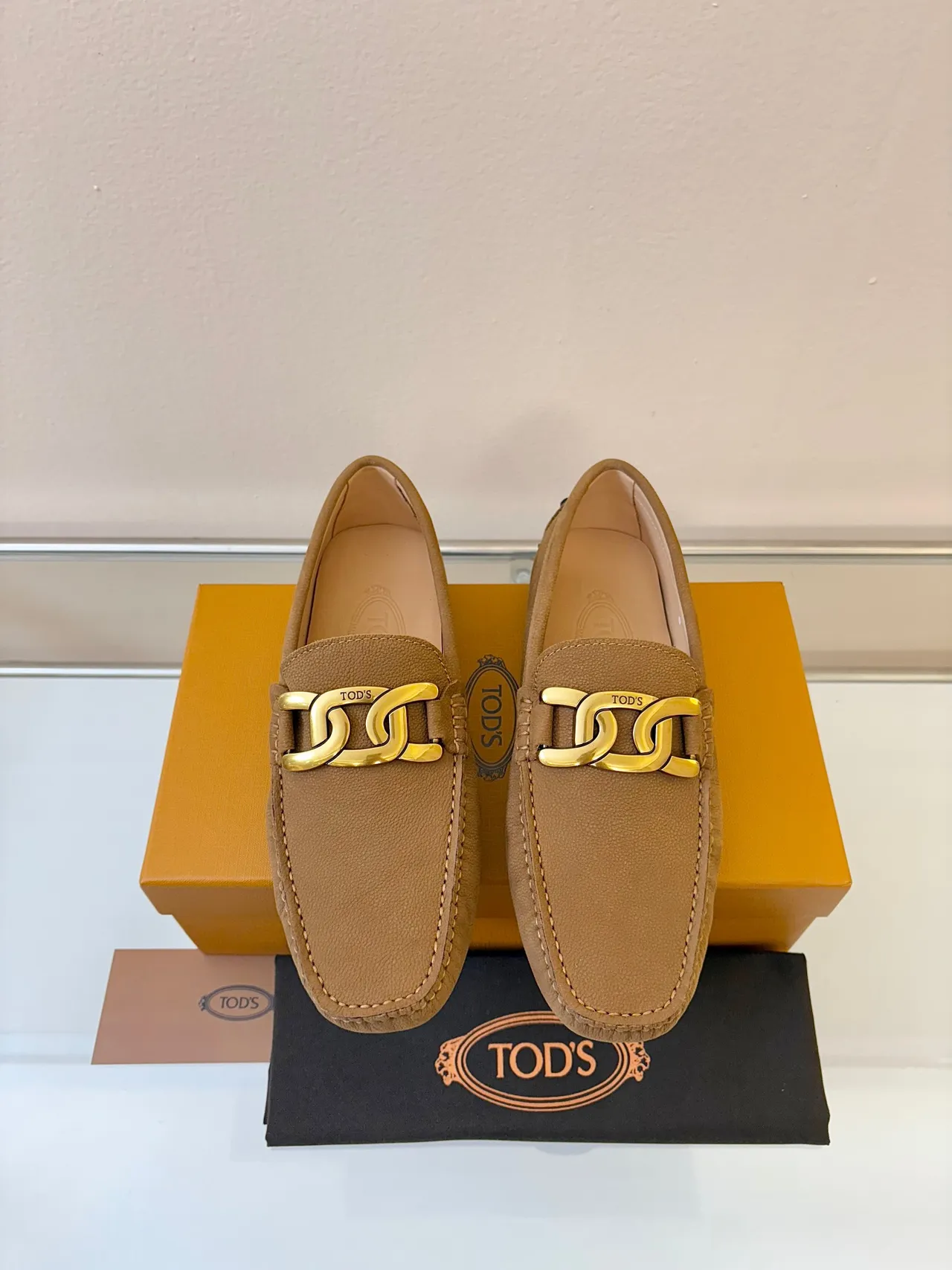 Mocassins Tod's Gommino de couro tan com textura pebbled e fivela de corrente de ouro 6