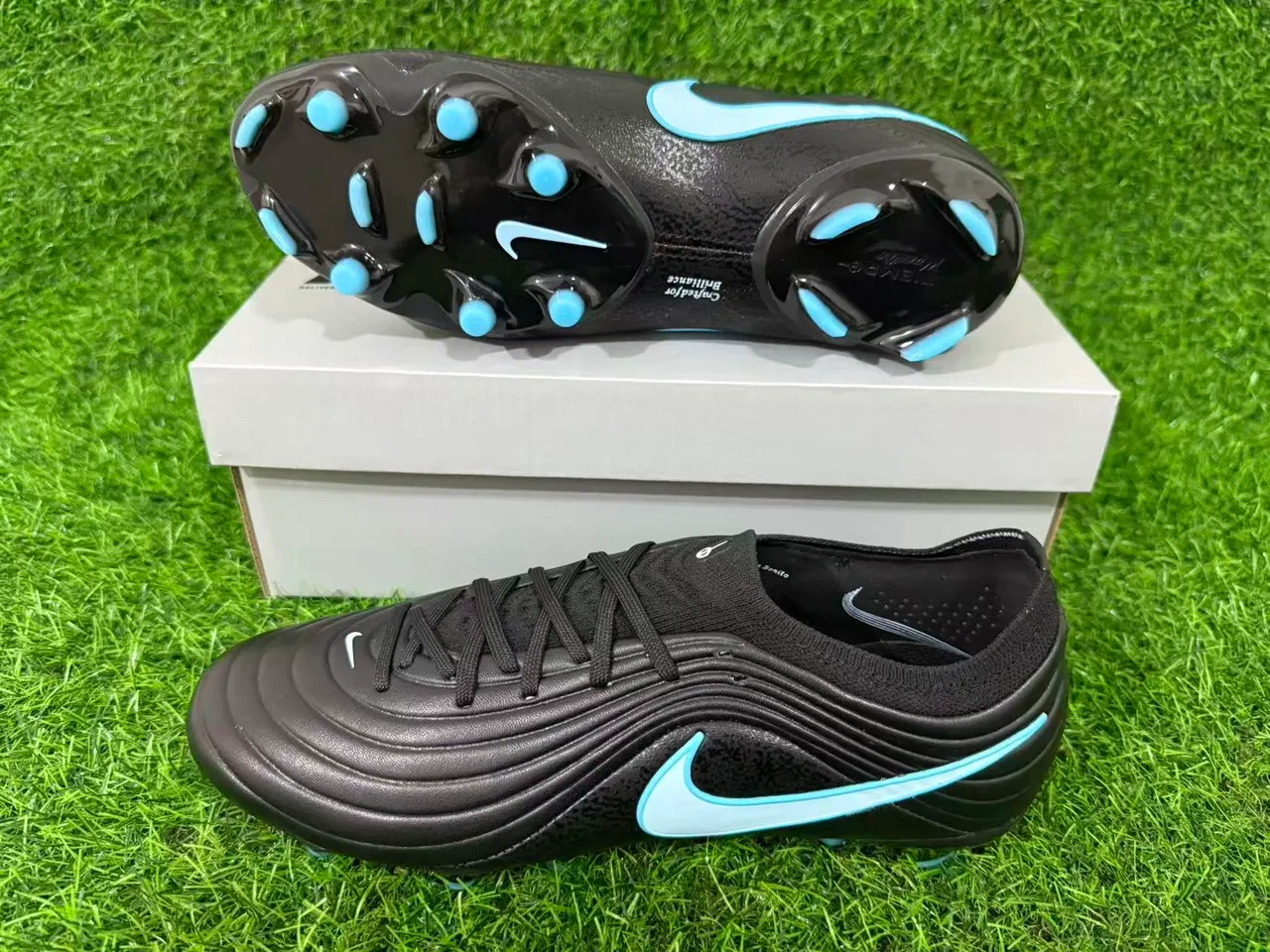 Nike Zapatos de fútbol negros y azules con empeine sintético ribeteado, cuello bajo y para terreno firme 16