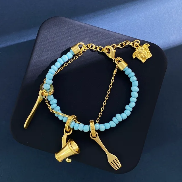 Pulseira azul e dourada adornada com contas e charms 4