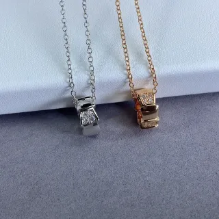 Collier avec pendentif en forme de nœud géométrique en argent et or pavé-set de pierres transparentes