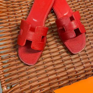Hermès Chinelos de couro texturizado com tira em forma de H vermelha