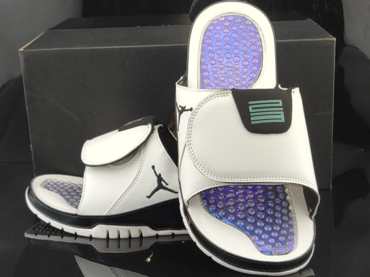 Chaussons Air Jordan blanc et noir avec tige en cuir et contrefort verni 4