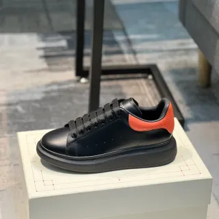 Alexander McQueen ओवरसाइज्ड स्नीकर काले और नारंगी प्लेटफॉर्म सोल चिकनी लेदर अपर लाइफस्टाइल स्नीकर