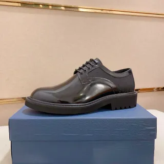 Calçado Oxford preto com ponta cap-toe e sola lug sole com acabamento glossy-matte two-tone