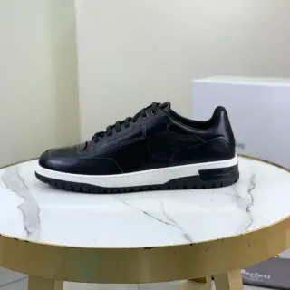 حذاء رياضي أسود أبيض جلدي مع أعلاه مثقوب في رأس الأصابع