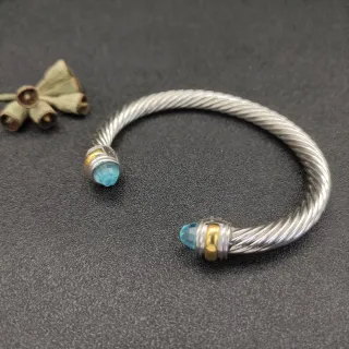 Pulsera plateada azul con cable trenzado y piedras facetadas en los extremos