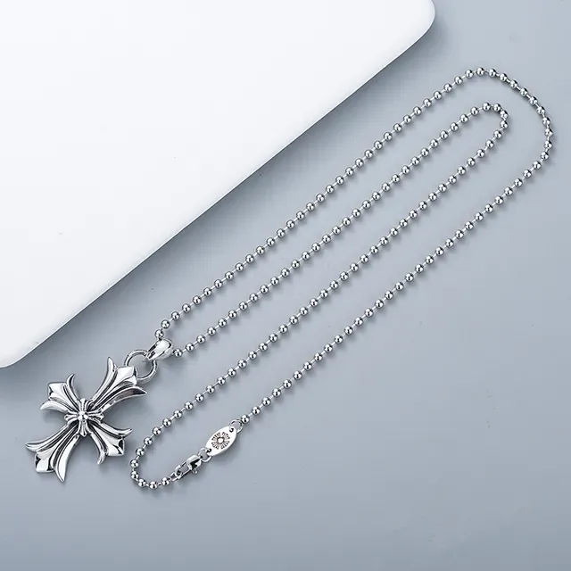 Colgante de cruz plateado ornamentado con brazos inspirados en flores 4