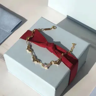 سوار سلسلة ذهبية بحلقات على شكل قلب بلون أحمر