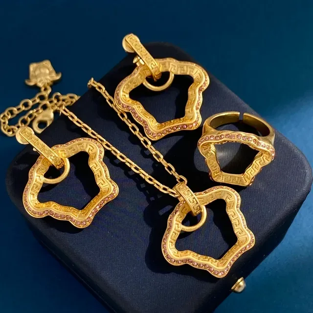 Boucles d'oreilles à bascule en ton doré avec motif de clé grecque et pierres pavées 3