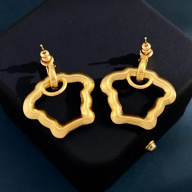 Boucles d'oreilles à bascule en ton doré avec motif de clé grecque et pierres pavées 4