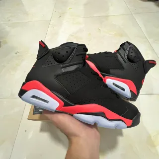 Tênis de basquete Air Jordan com silhueta de cano alto e cabedal de couro perfurado preto e vermelho