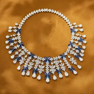 Collier avec motif floral blanc et bleu et éléments de dangle en forme de larme