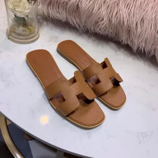 صنادل مسطحة جلد منسج بلون تان مع حزام H من Hermès Oran