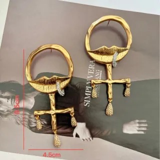 Brincos de cristal com gota e motivos de lábios e cruz em tom dourado