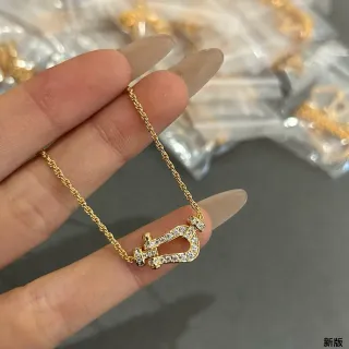 Collier avec pendentif en forme de fer à cheval de ton doré avec cristaux pave