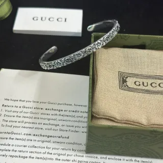 سوار معصم Gucci زهوري و G متشابكة منقوش بلون فضي مفتوح