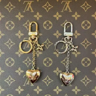 Louis Vuitton llavero en forma de corazón de oro y plata con colgante y grabado del monograma LV