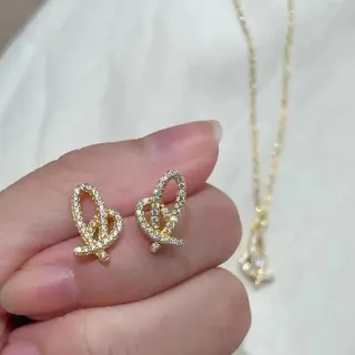 أقراط ذهبية اللون بكريستال مرصعة بطريقة Pavé على شكل عقدة