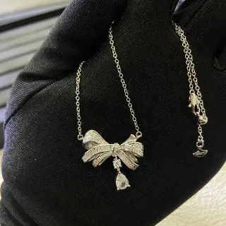 Collier avec pendentif en forme de nœud argenté blanc avec pierres pavé-set