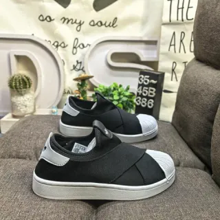 Adidas أحذية رياضية سوداء وبيضاء سليب أون مع شريط متقاطع مرن للأسلوب الحياتي