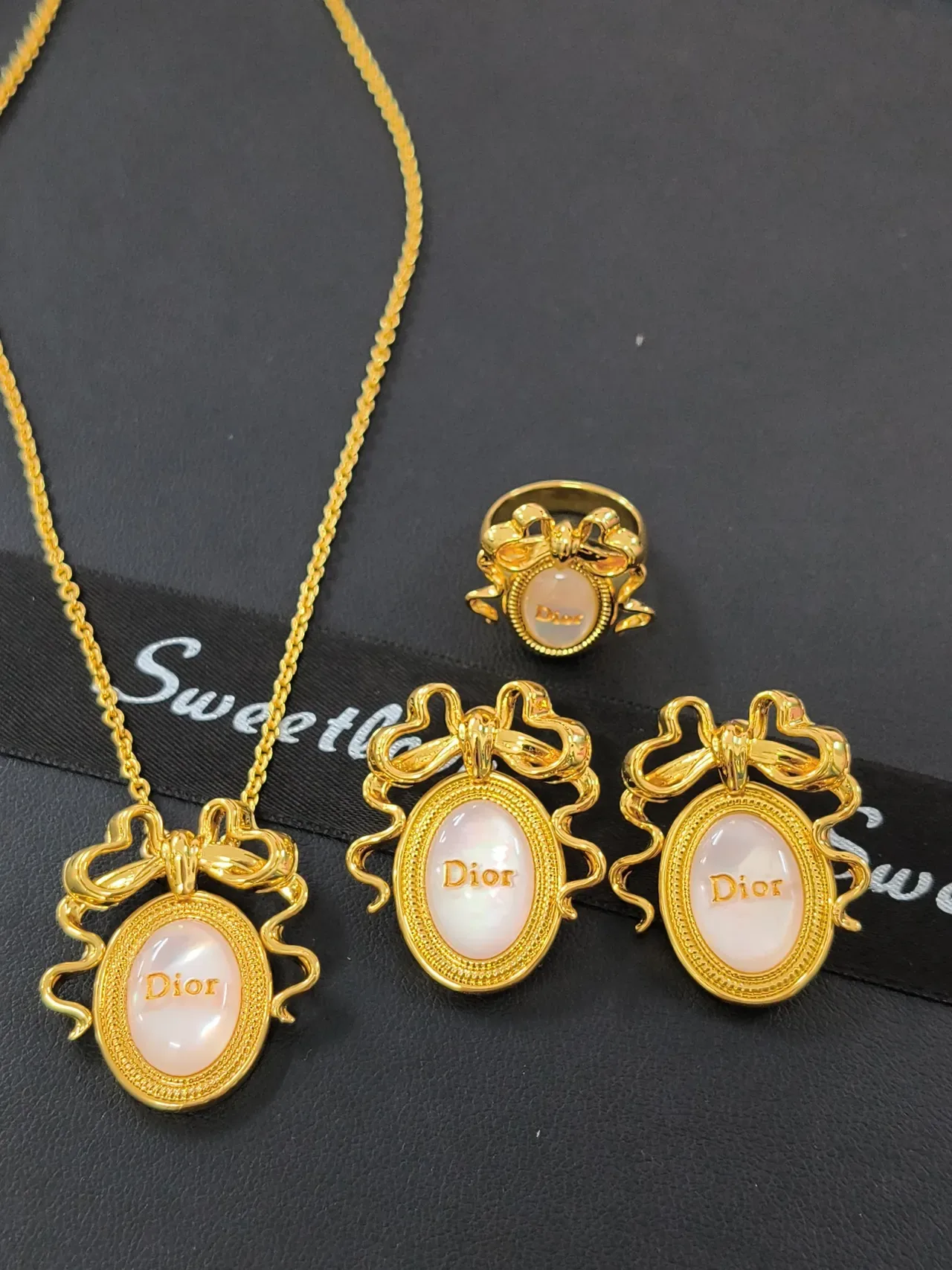 قلادة Dior La D de ذهب بزخرفة فيونكة وردية وكابوشون بيضاوي من عرق اللؤلؤ 2