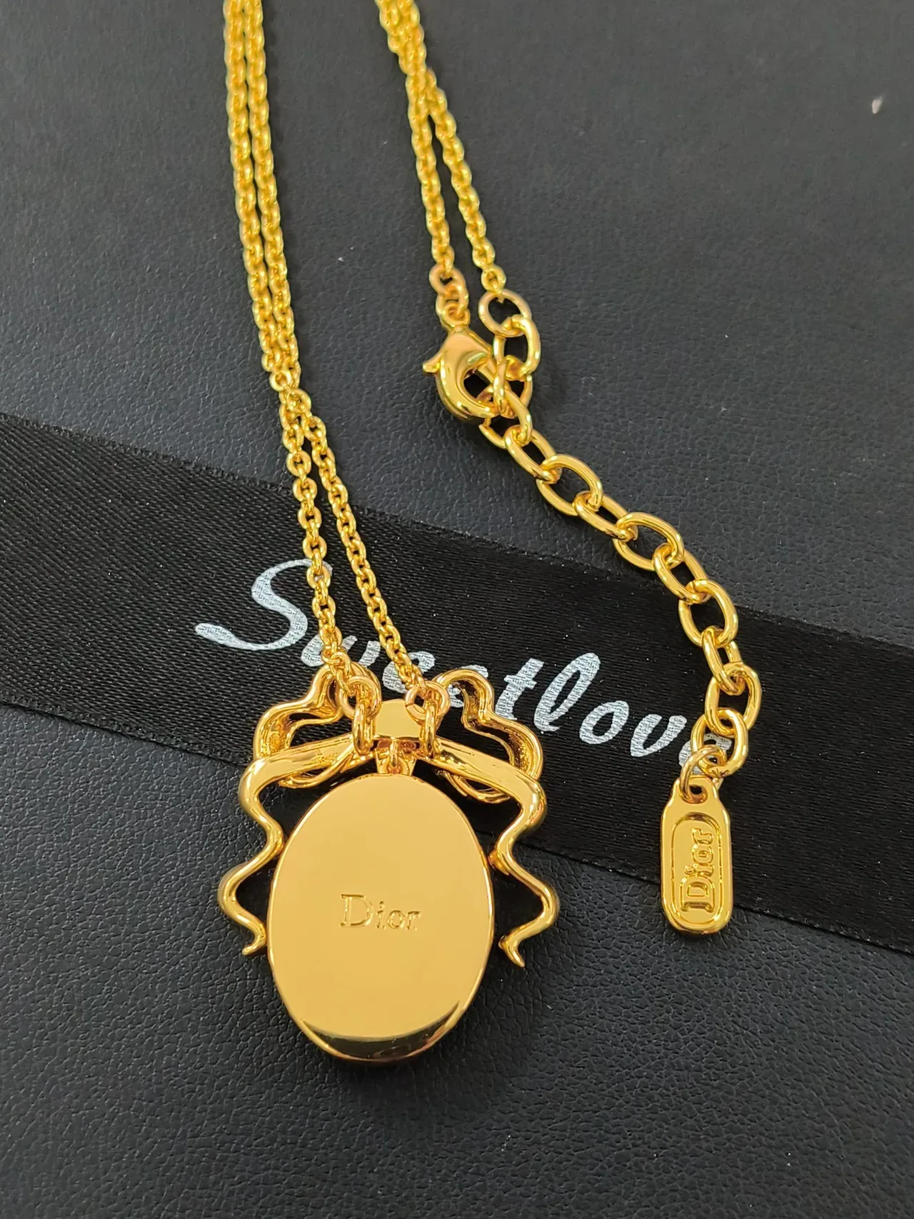 قلادة Dior La D de ذهب بزخرفة فيونكة وردية وكابوشون بيضاوي من عرق اللؤلؤ 3