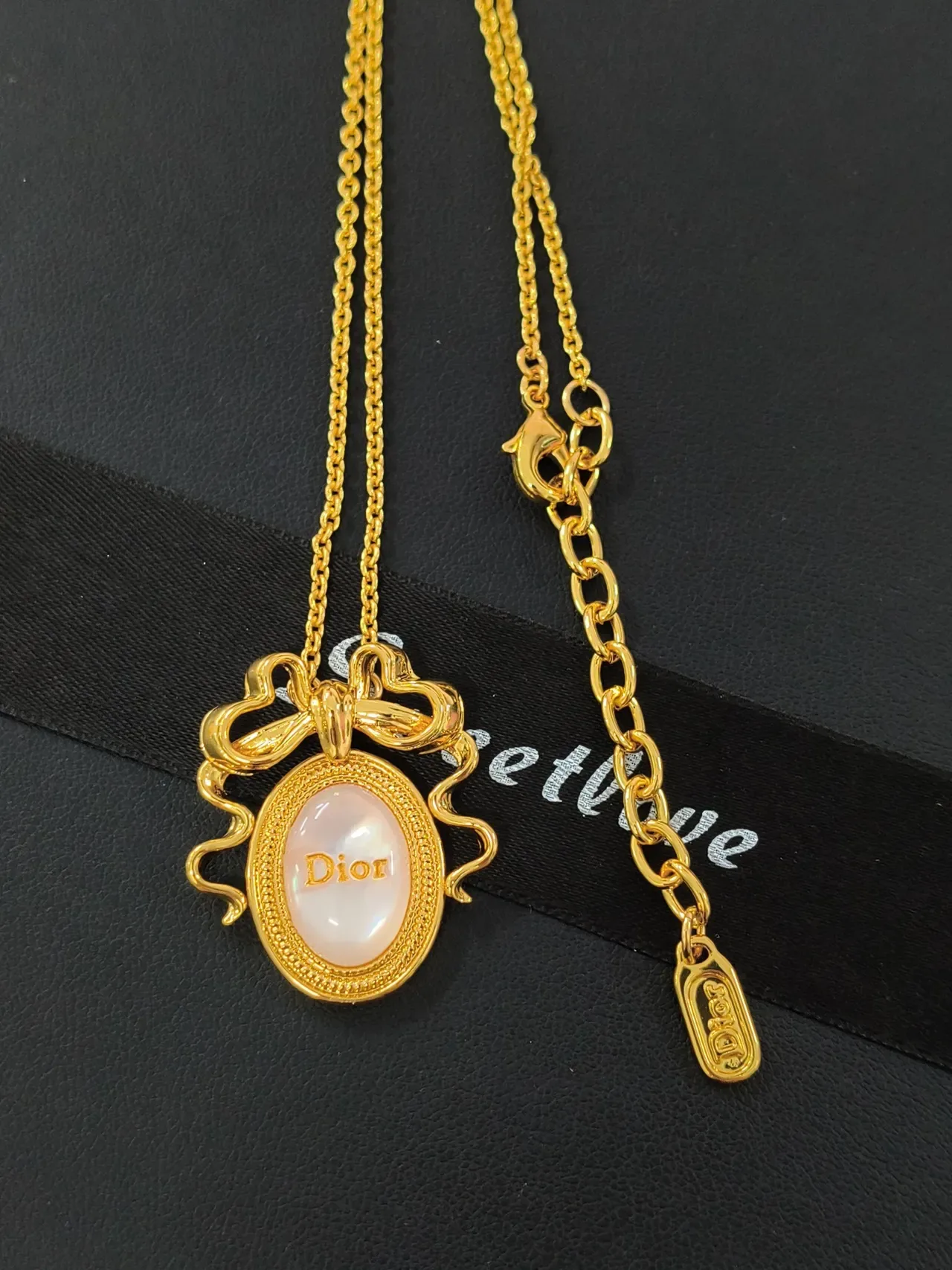 قلادة Dior La D de ذهب بزخرفة فيونكة وردية وكابوشون بيضاوي من عرق اللؤلؤ 4