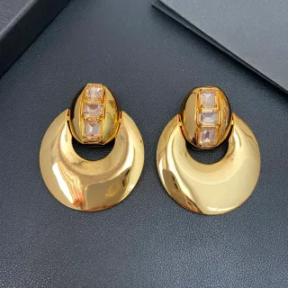 Aros de tono dorado con piedras facetadas geométricas escultóricas