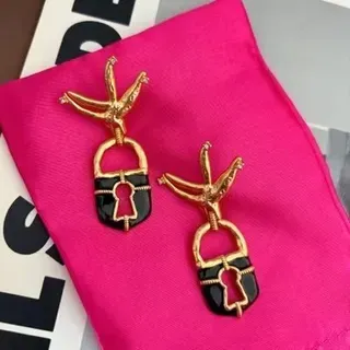 Brincos esmaltados pretos e dourados com forma de cadeado e motivo de pássaro