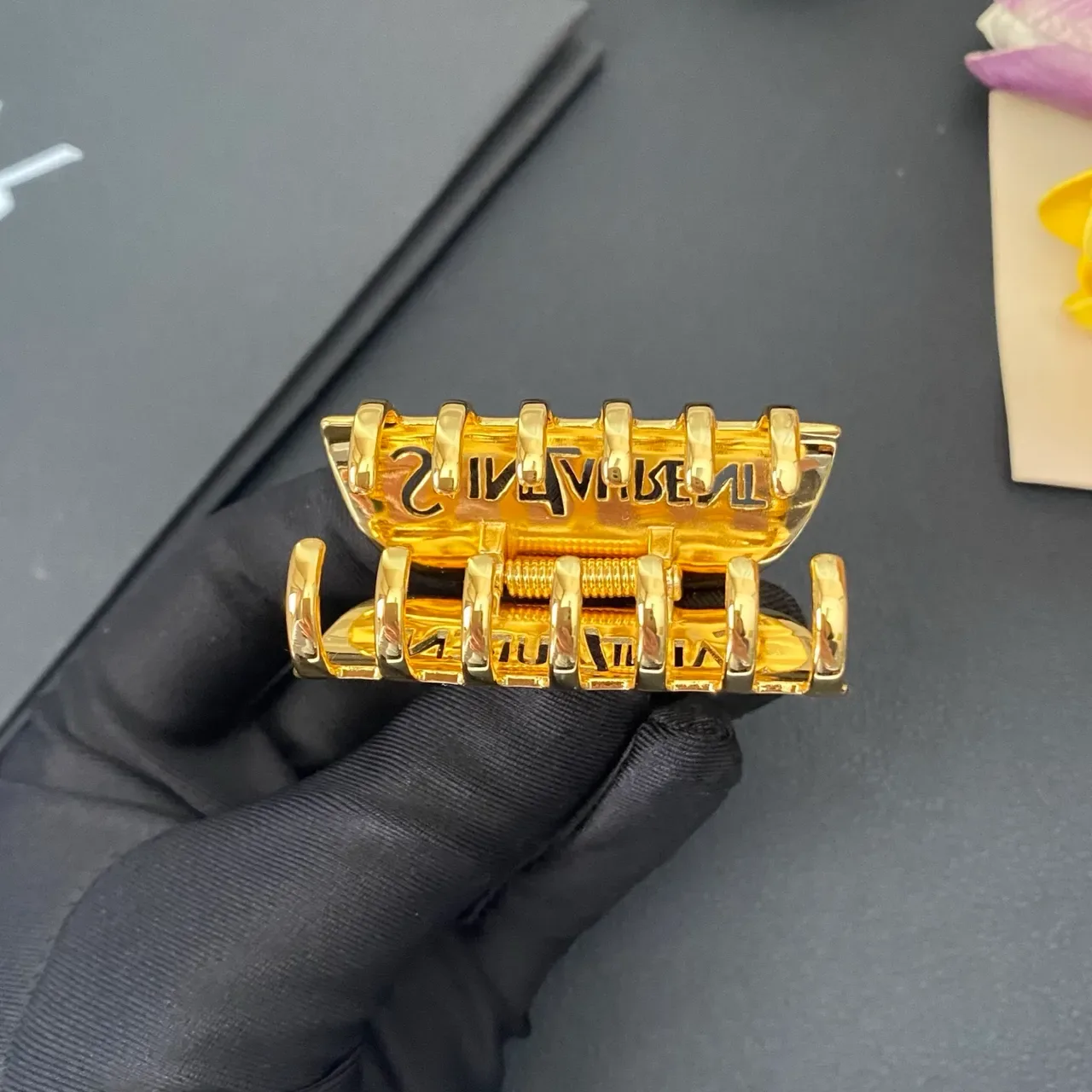 Broche Saint Laurent de metal pulido dorado grabado con branding 4