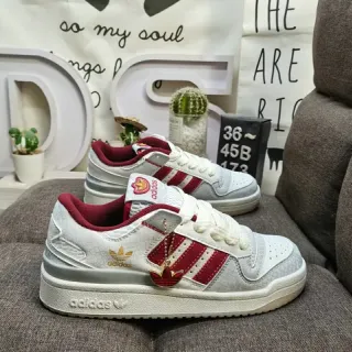 Adidas حذاء رياضي أبيض أحمر منخفض الظهر مع أصابع مُثقبة للأسلوب الحياتي