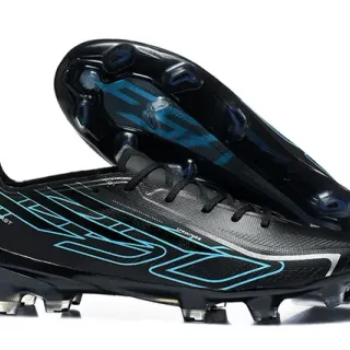 Chaussures de football à semelle ferme noires et cyan