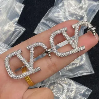 Brincos com forma de letra pavimentados com cristais