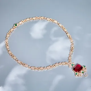 Collier pendentif de ton doré avec gemmes rouges et accent émeraude