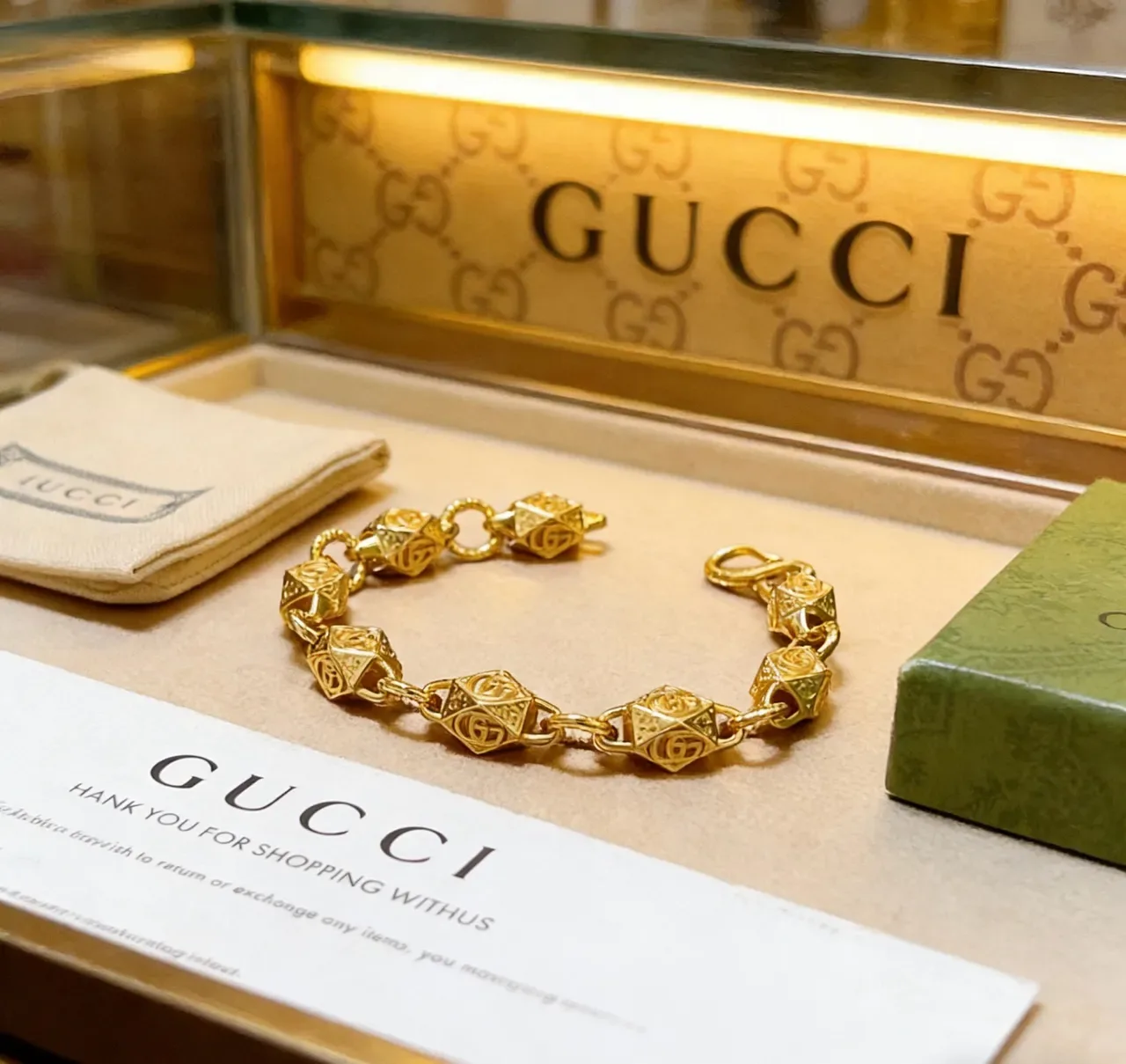 Gucci Pulsera dorada con eslabones geométricos facetados interconectados motivo GG 9