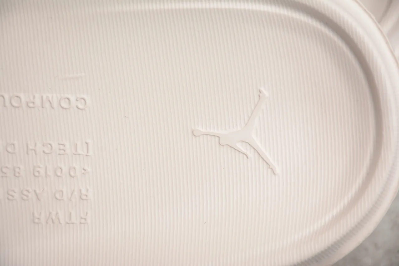 Claquettes Air Jordan beige et gris avec bride moulée et tige perforée 3