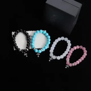 Pulsera de cuentas negras y rosadas elástica con encanto de cruz