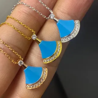 Colgante de esmalte en forma de abanico de azul y oro con borde de cristales pavé