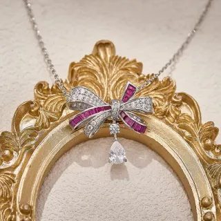 Collier pendentif en forme de nœud rose argenté avec accents de rubis taillés en baguette