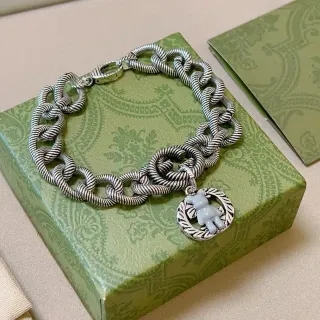 Pulsera con charm de oso esmaltado y enlaces de cuerda retorcida