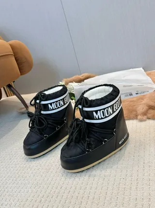 Botas de nieve con cordones aisladas en negro y crema 4