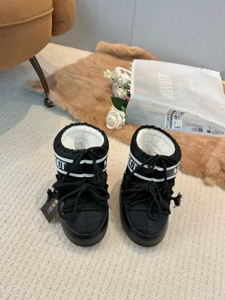 Botas de nieve con cordones aisladas en negro y crema 7