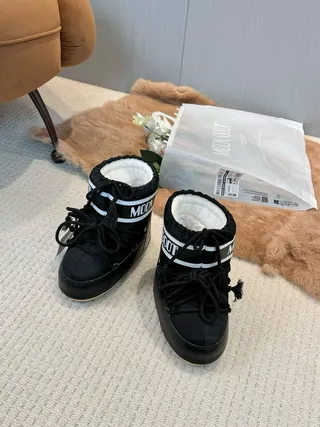 Botas de nieve con cordones aisladas en negro y crema 9